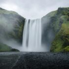 waterfalls on green grass covered mountain during daytime