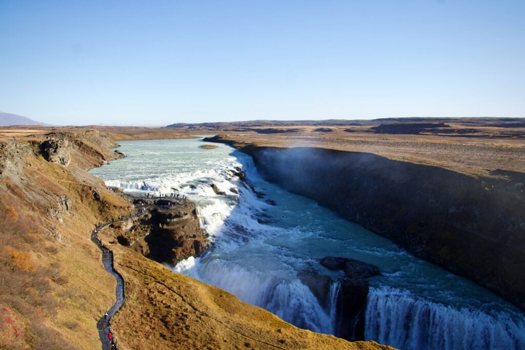 Majestic waterfall cascading into a canyon under a clear sky