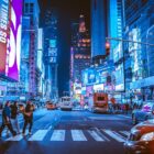 People crossing a street in Times Square, New York City, under bright neon signs