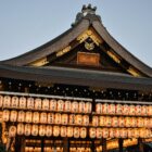 Glowing lanterns lighting up a temple pavilion in Kyoto at dusk