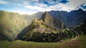 Sunrise light over the terraced ruins of Machu Picchu with green mountains behind