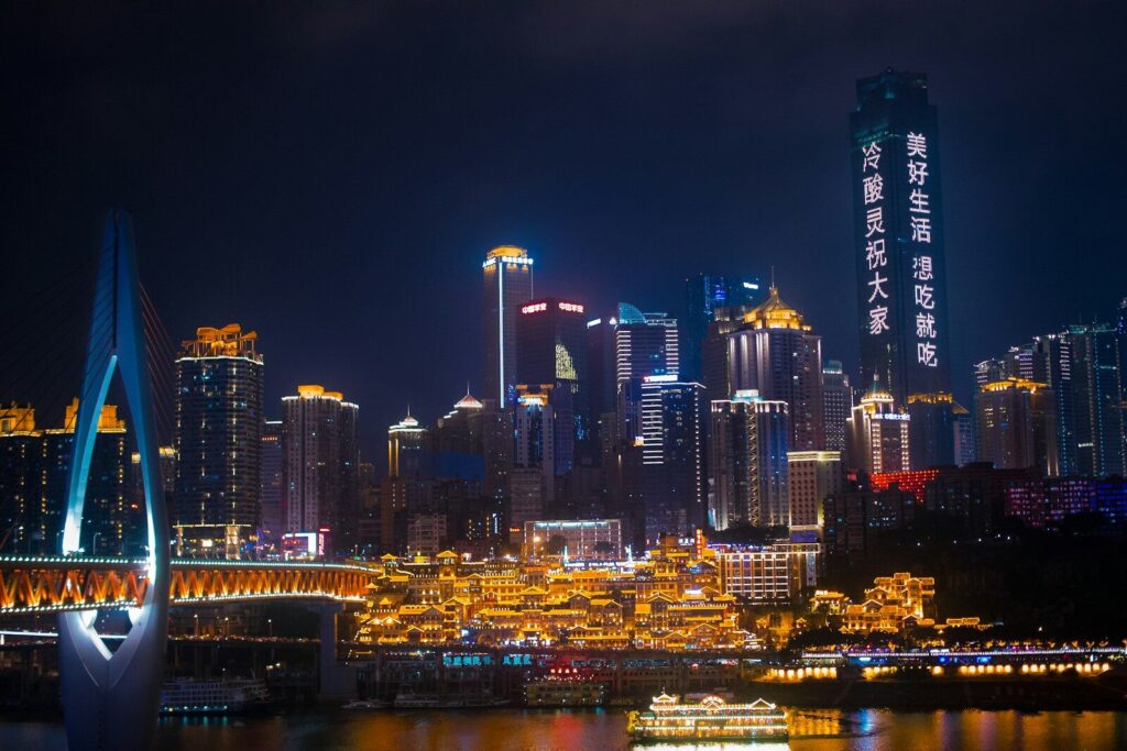 a city skyline at night with a bridge in the foreground